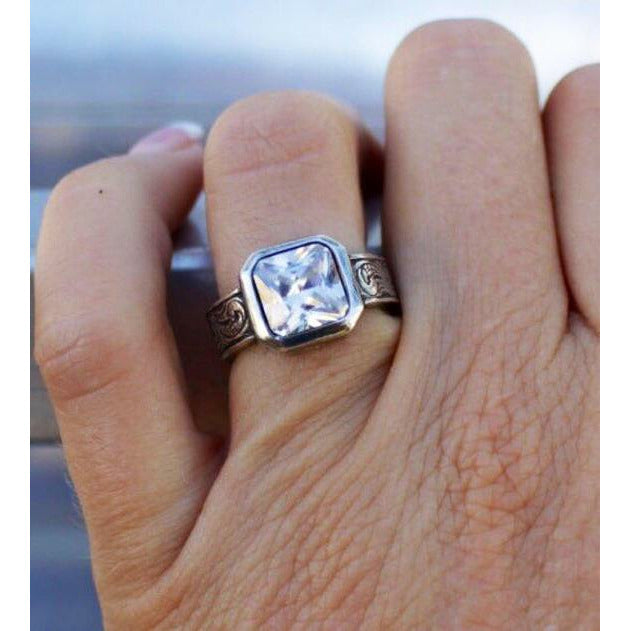 sterling silver ring with a beautiful 8mm x 8mm radiant cut bezel set cubic zirconia on a western engraved band.