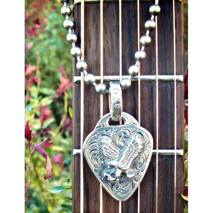 Sterling Silver guitar pick pendant with an eagle spreading his wings finished off with a beautiful hand engraving around the eagle.