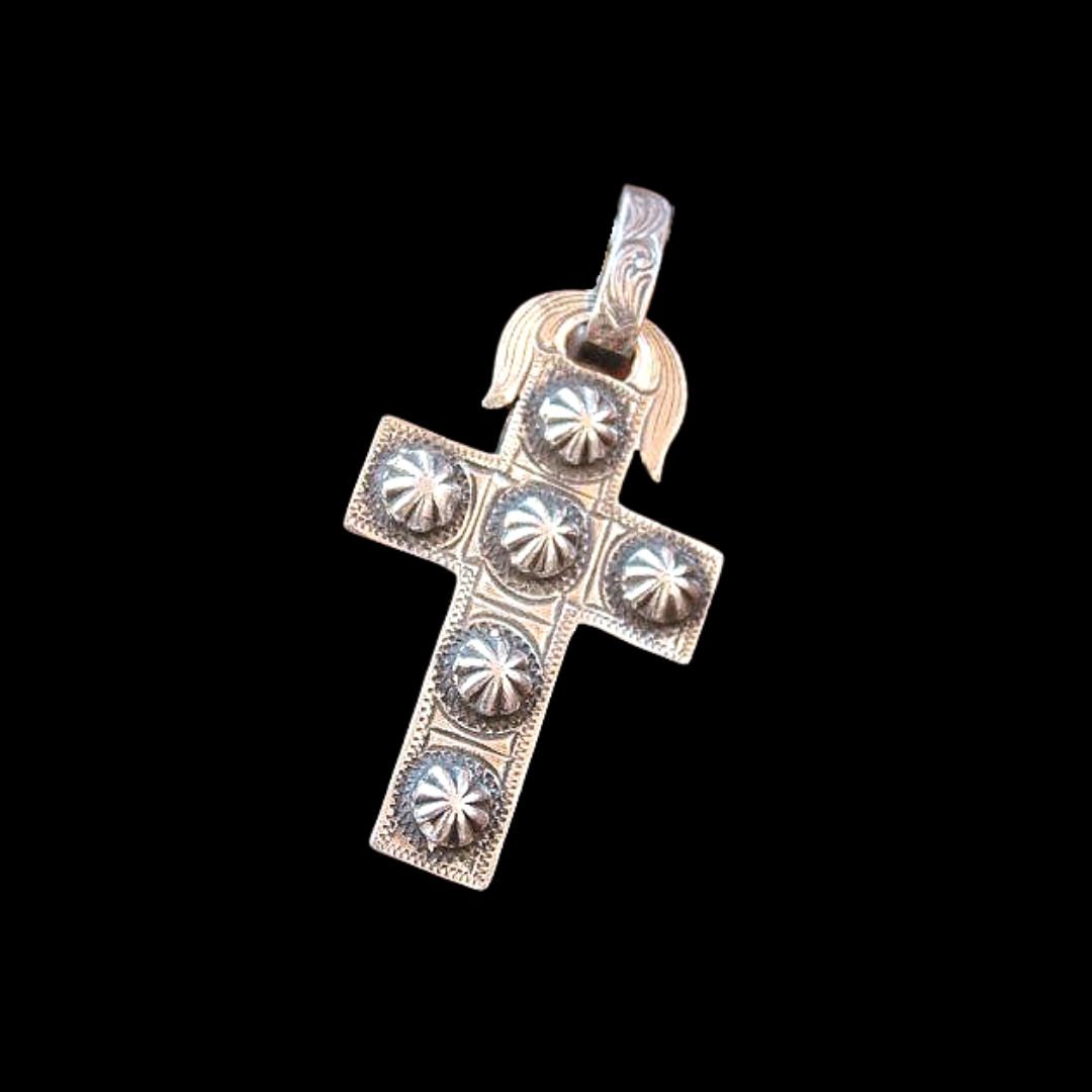 The "Maisie" Cross pendant is a custom solid sterling silver pendant that features very unique engraved antique nail heads and a western style hand engraved scrolling. The cross measures at 1 1/8" x 1 3/4".