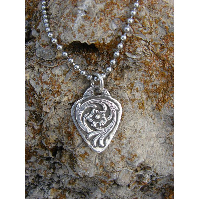 The "Miranda" Necklace is a handmade solid sterling pendant that is in the shape and size of a standard guitar pick featuring a hand engraved floral pattern. It measures 1" x 1-1/4". (Options available in all sterling silver, or small Kingman Turquoise stone in the middle of pendant)