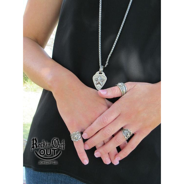 The "Buster" Ring is a handcrafted sterling silver ring that has a unique border with a bucking horse featured in the middle of the ring and a star and western engraving on each side of the ring.