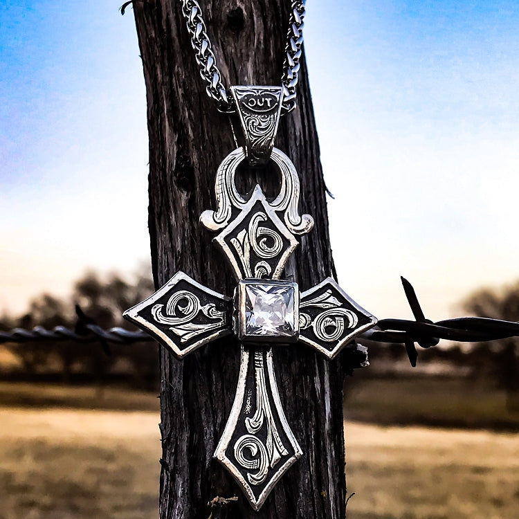 The "King Knight Cross" Pendant is a stunning handmade large sterling silver cross that features a 10mm a beautifully hand carved decorative bezel set cubic zirconia or Kingman stone along with a western style overlaid hand engraved scrolling throughout the entire cross. The cross measures at 3" X 2".