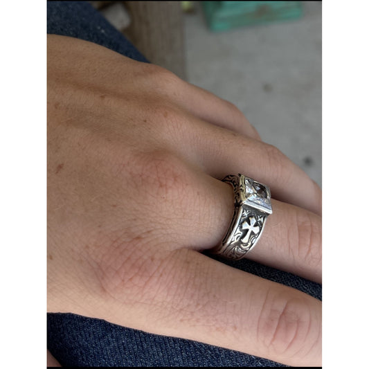 "Madison" is a handmade solid sterling silver ring with a low-profile bezel set 8mm Cubic Zirconia. This beautifully unique ring features an overlaid cross on either side of the band with intricate scroll work on the front and back edges of the ring and around the stone. This elegant ring offers our most comfortable fit.