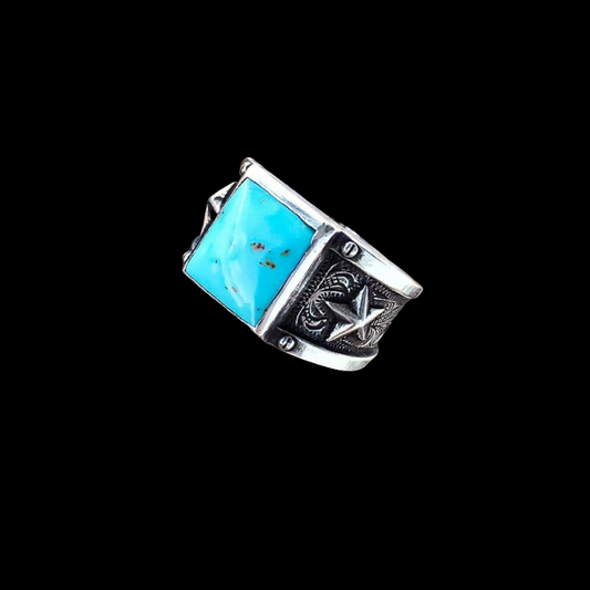 solid, sterling silver ring that features a 10x10mm Genuine Kingman Turquoise stone in the center of two raised stars and a slick border on top and bottom of western style engraving around the band. 