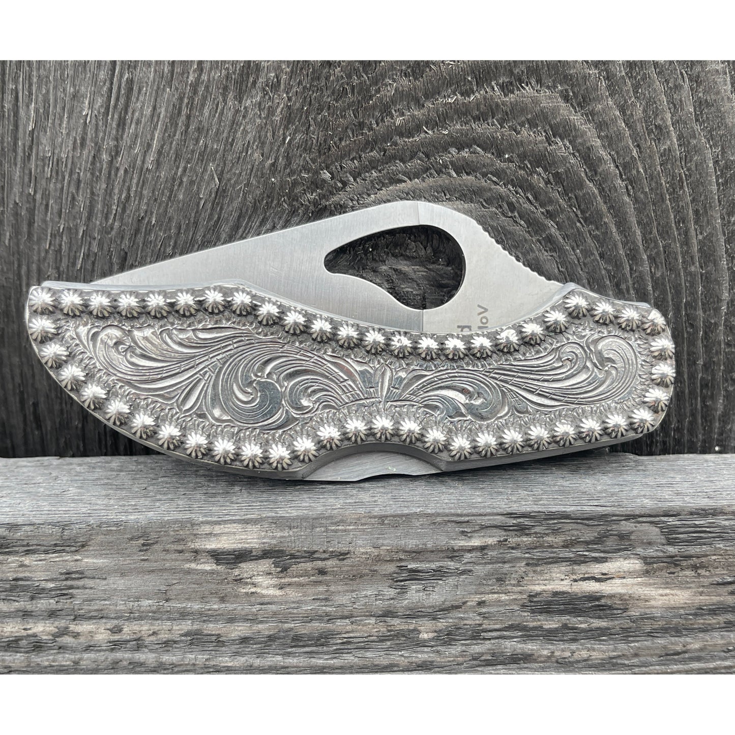 Sterling silver Byrd knife with custom hand engraving surrounded by a beaded border.