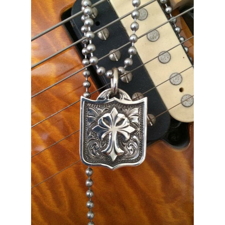 The "Guardian" Pendant is custom a solid sterling silver unique pendant that features western style hand engraved scrolling with an overlaid cross. It's perfect for casual everyday wear. It measures at 1"x 1".