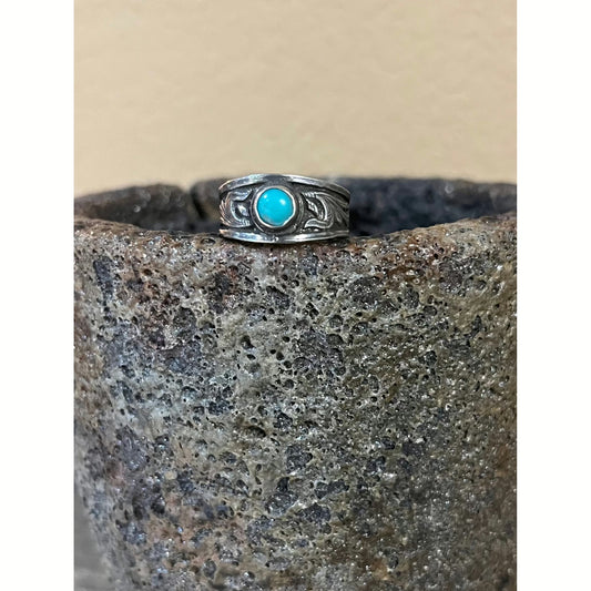 Cheyenne is a sterling silver ring with a tapered band complimented by a overlaid western style scroll work on each side of the ring. This ring features a 6mm Kingman Turquoise stone. 