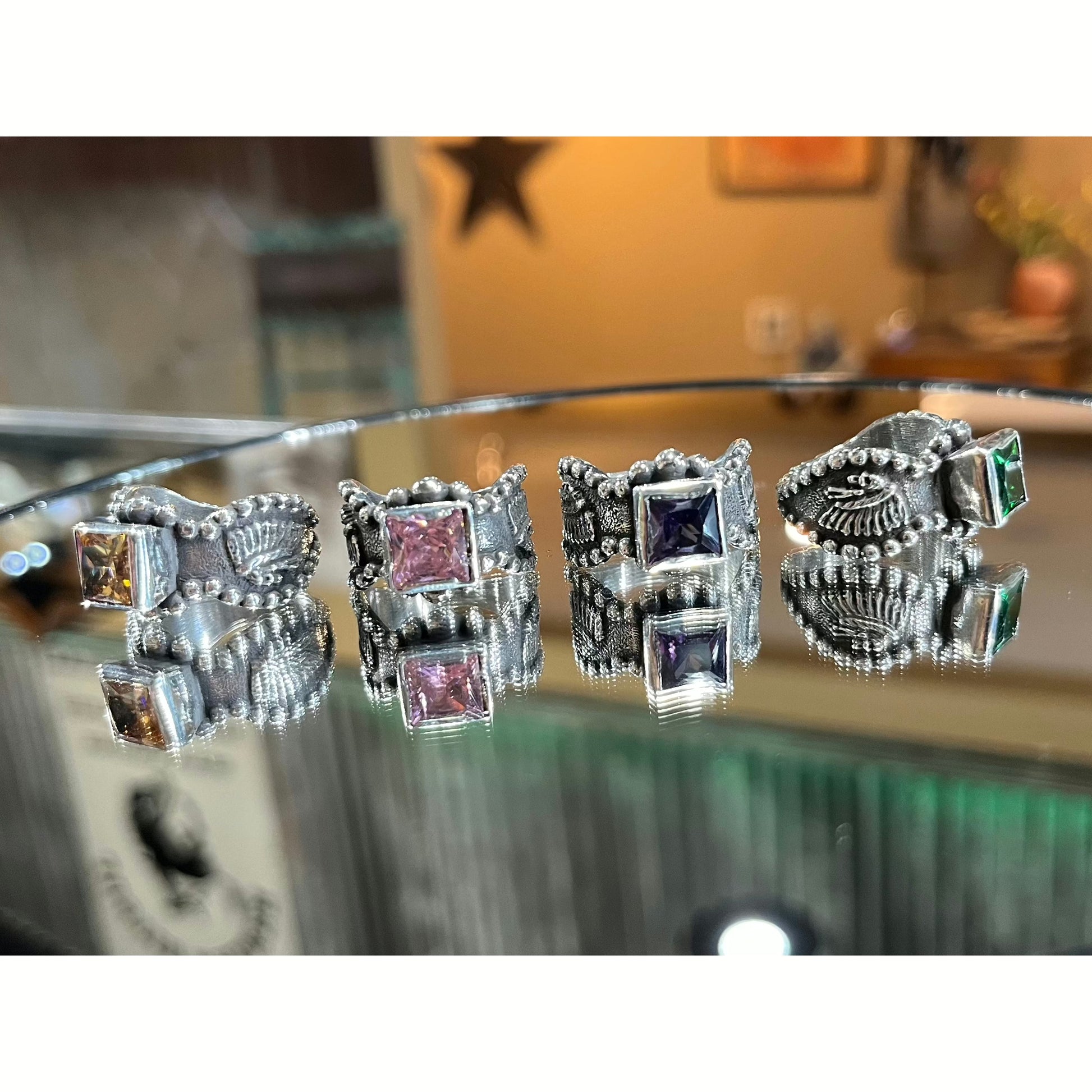 "Dakota" is a handmade sterling silver ring that has a unique border all the way around the ring with an 8mm bezel set princess cut cubic zirconia that features an overlaid 3D Indian Chief head on each side of the ring.