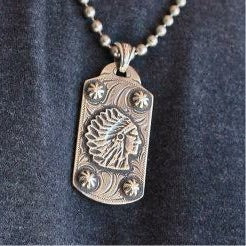 Rockin Out Jewelry's "Indian Head" Dog Tag is a custom solid sterling silver pendant that has rich American West history. Featuring the overlaid Indian head chief along with antique nail heads accented by the western style engraving. This dog tag is standard size measuring 1" x 2".