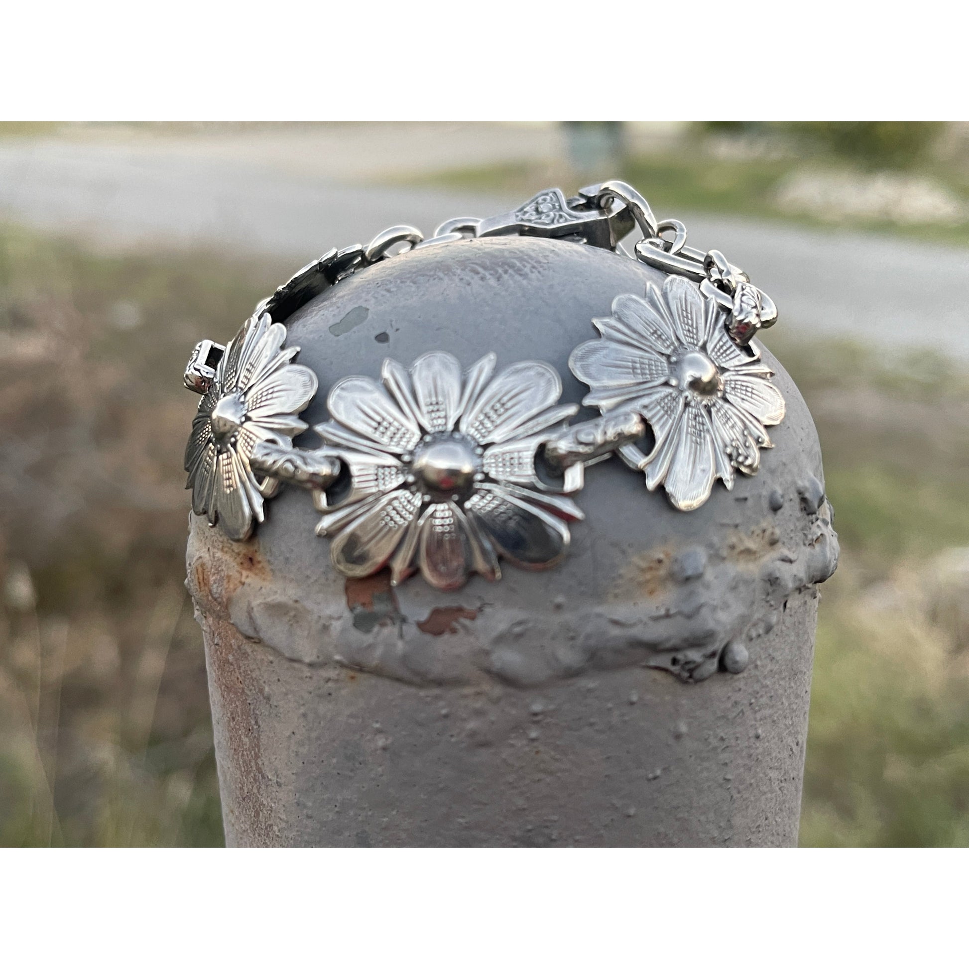 The "Daisy" handmade sterling silver link bracelet features hand engraved flowers connected with small hand engraved links and has our Rockin Out logo on the inter-locking clasp.