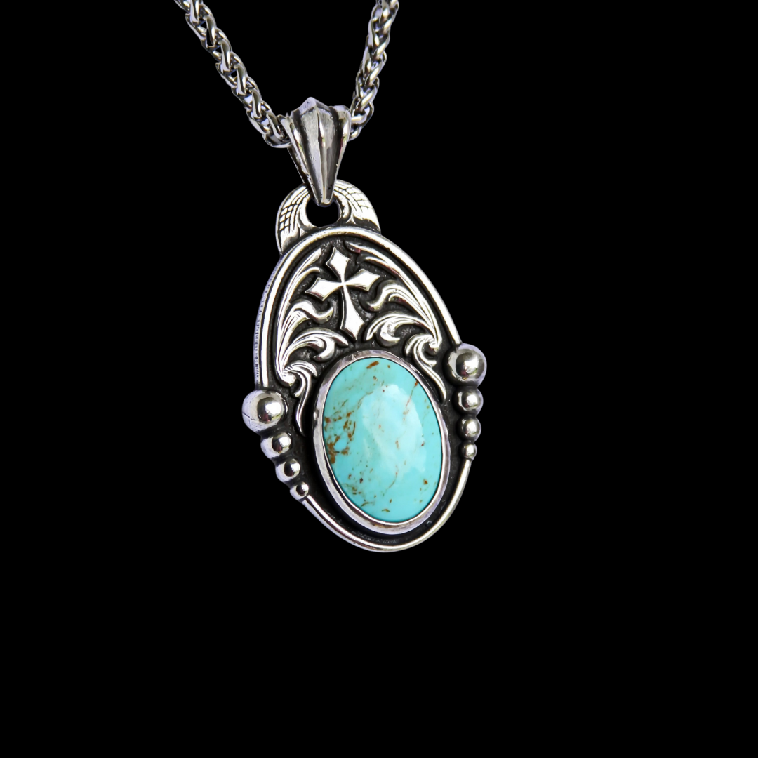 The "Jude" Necklace is a handcrafted heavy sterling silver pendant with a smooth and scalloped border that surrounds the entire pendant with a western style hand engraved scroll and cross overlay and features an 18mm x 25mm oval bezel set Kingman Turquoise Stone from the Kingman Mines in Kingman, AZ.
