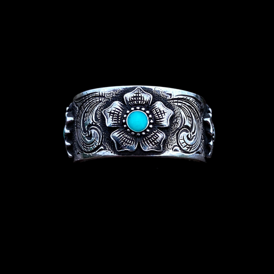 “Magnolia” is a custom women’s solid sterling silver band that features western style hand engraving accented with 3 beautiful, engraved magnolias that are filled in the center with turquoise inlay. This hefty band is about 10.5mm wide and heavy duty enough for everyday wear! 